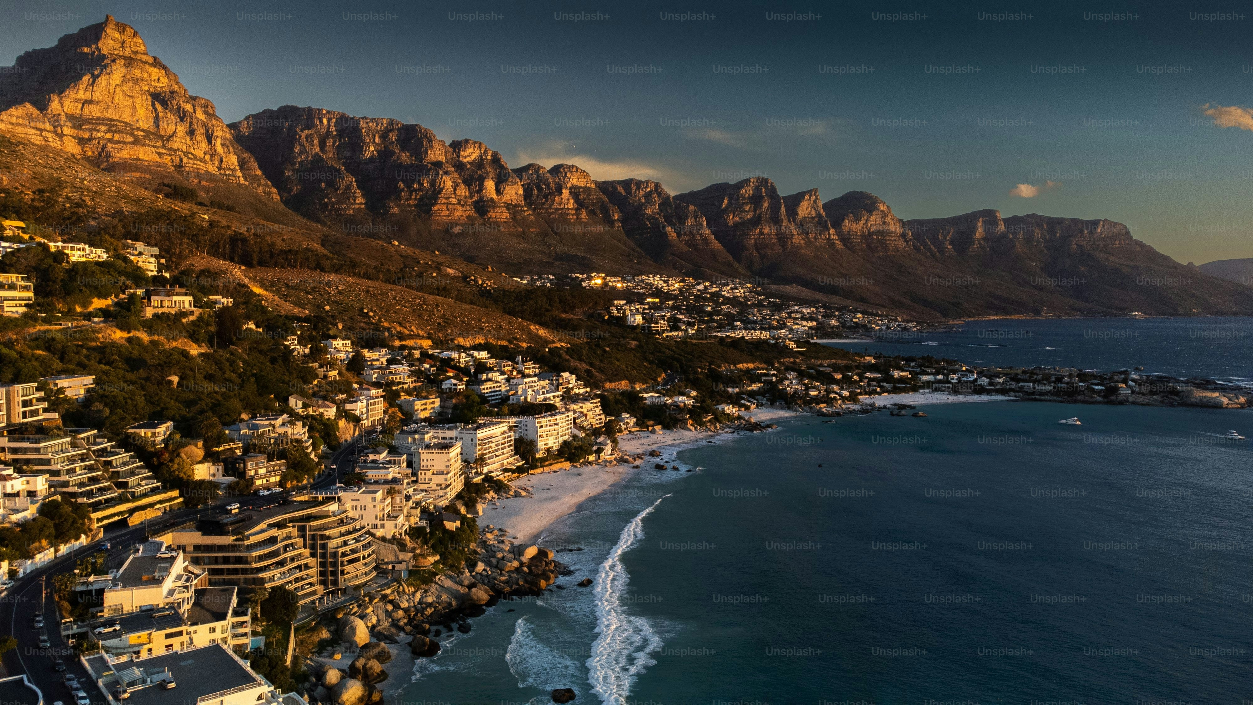 An aerial view of the coastal city and Clifton Beach in Cape Town, South Africa during sunset
