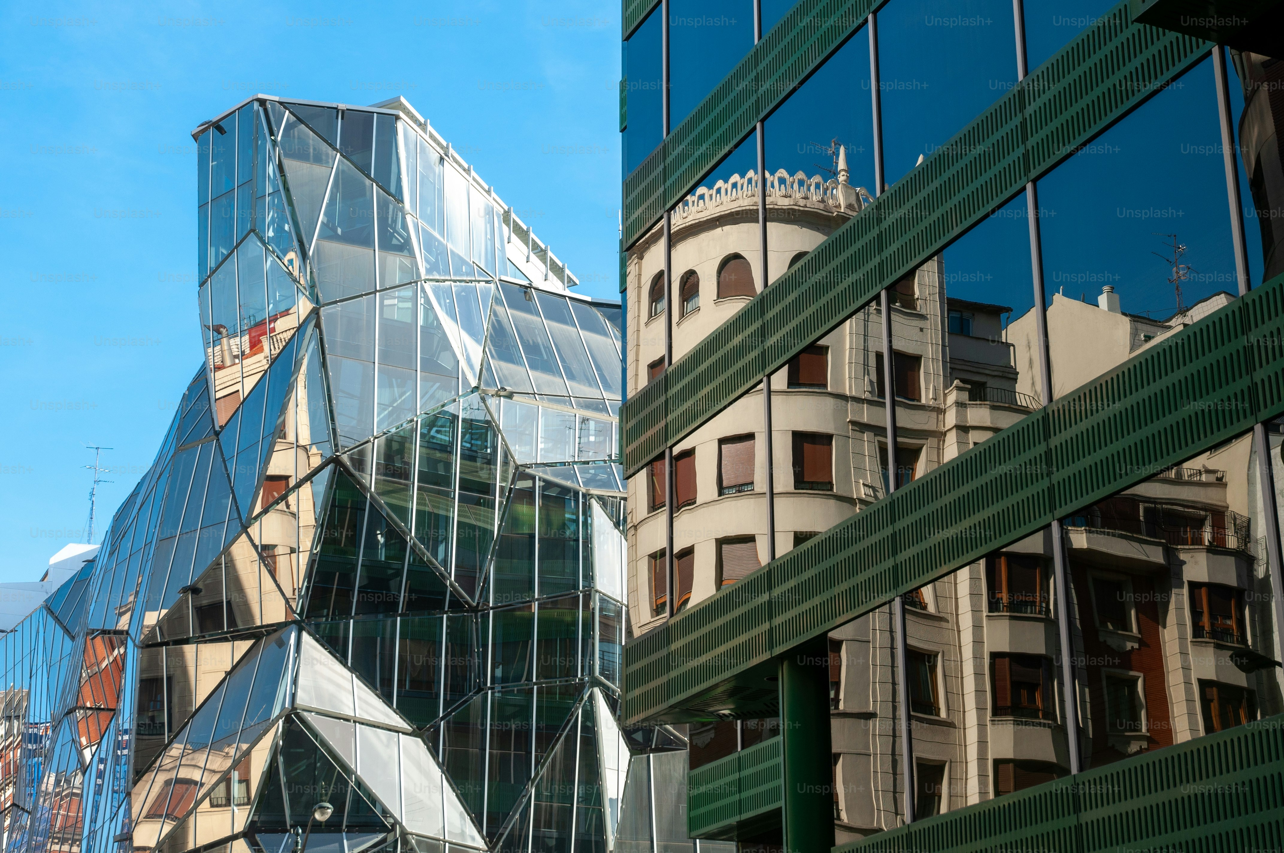 Eine schöne Aufnahme von zwei Glasgebäuden mit abstrakter Architektur in Bilbao, Spanien