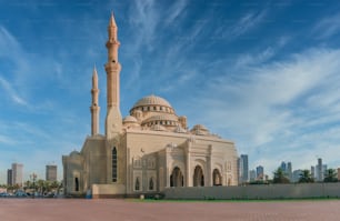 Una toma de ángulo bajo de una mezquita en Sharjah, Emiratos Árabes Unidos con un cielo azul en el fondo