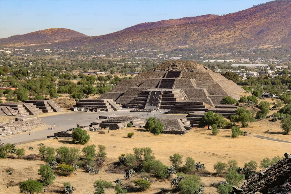 An aerial shot of the Pyramid of the Moon with mountains in the background in Teotihuacan, Mexico
