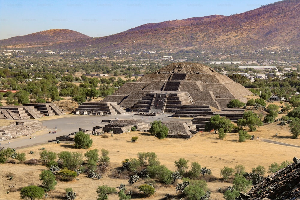 Uma foto aérea da Pirâmide da Lua com montanhas ao fundo em Teotihuacan, México