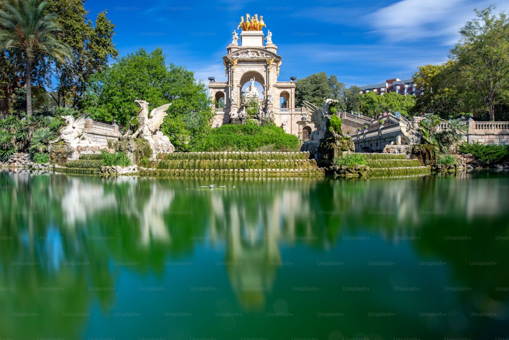 Eine schöne Aufnahme des Ciutadella-Parks mit einem Teich vor Skulpturen in Barcelona, Spanien
