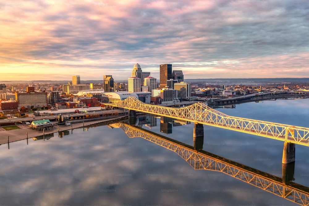 An aerial shot of the skyline of Louisville and the bridge at sunrise.