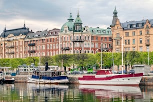 Uma bela vista dos barcos no rio perto dos edifícios em Estocolmo, Suécia