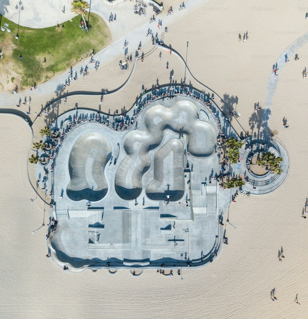 An aerial of the Venice Beach Skatepark with people gathered around it on a sunny day in LA, California