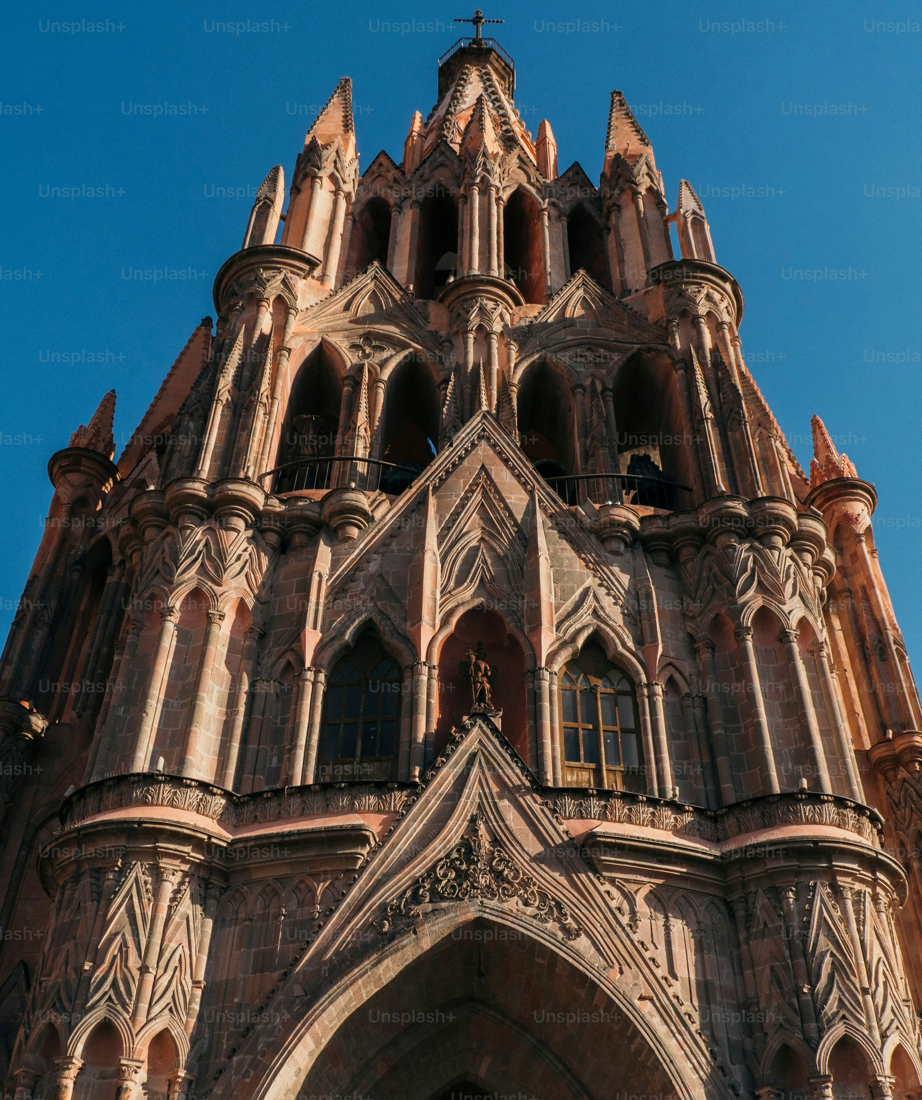 Un ángulo bajo vertical de la iglesia de la Parroquia de San Miguel Arcángel en México contra el cielo azul