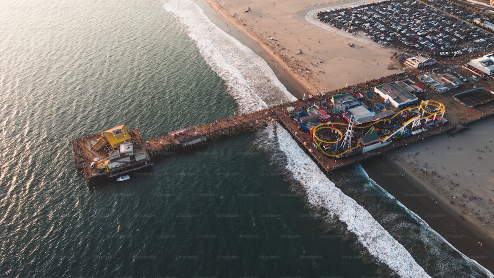 An aerial shot of the Santa Monica Pier surrounded by the sea on a sunny day in California