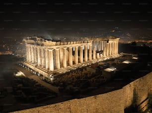 An aerial shot of the Parthenon temple at night in Athens, Greece.
