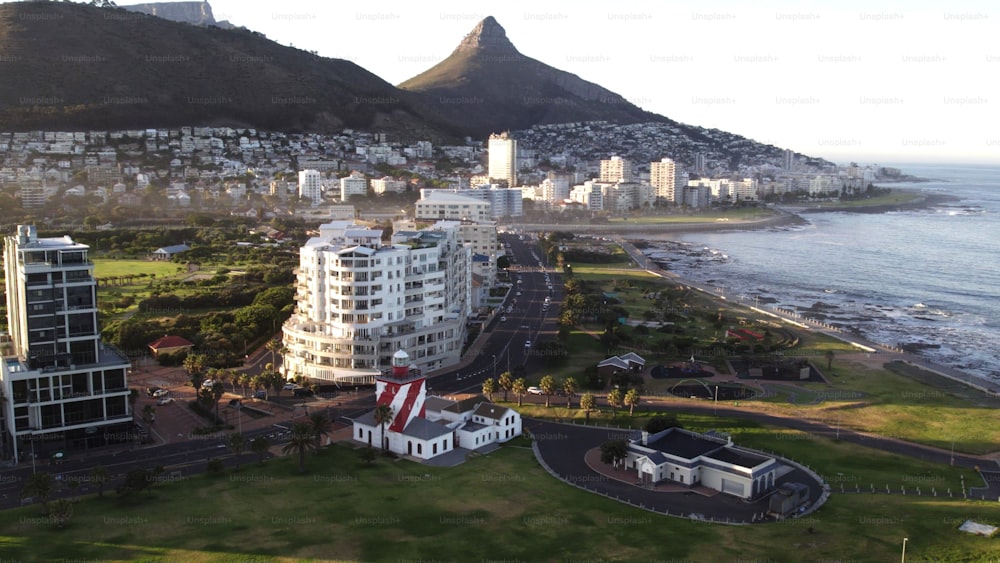 Um tiro de drone de edifícios residenciais e do Farol de Green Point perto da costa na Cidade do Cabo