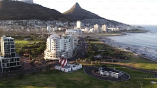 A drone shot of residential buildings and the Green Point Lighthouse near the shore in Cape Town