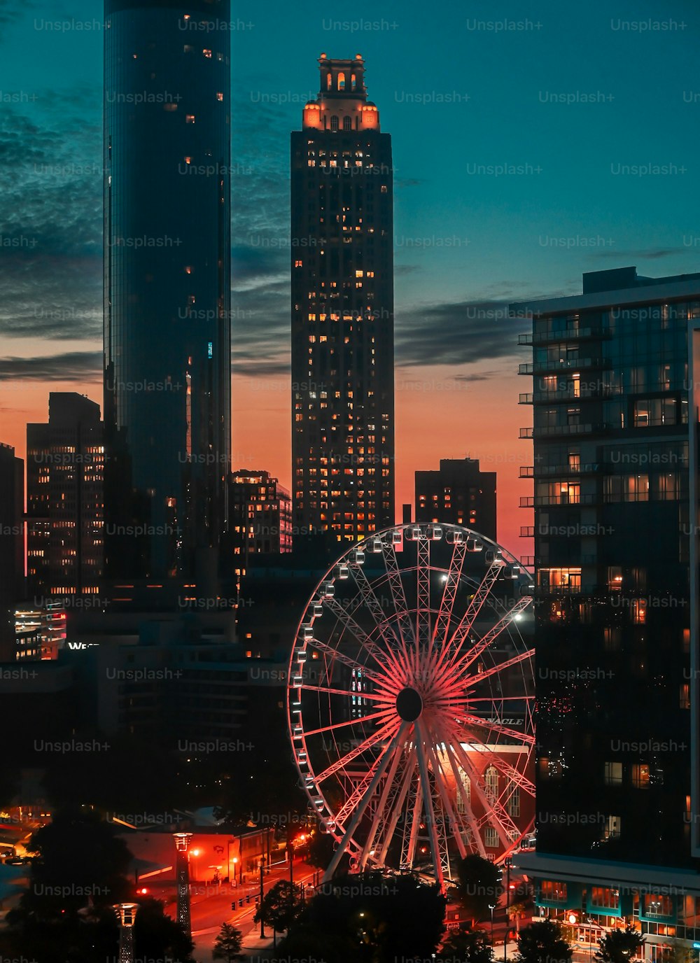 Una veduta aerea della città di Atlanta con una serie di alti grattacieli con una grande ruota panoramica in primo piano