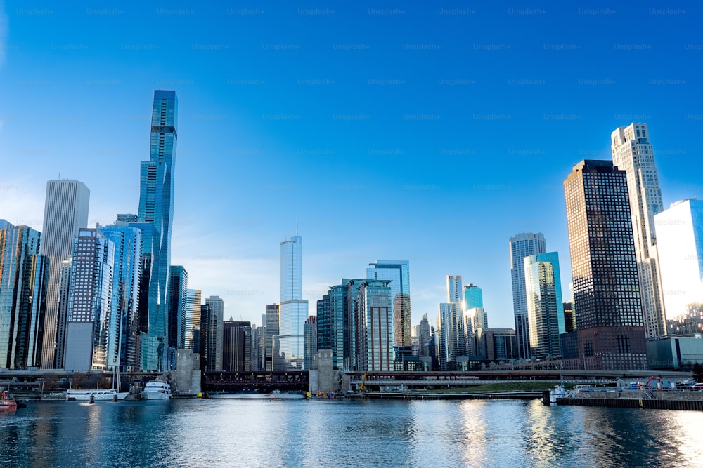 Das Stadtbild von Chicago mit dem See im Vordergrund und einem strahlend blauen Himmel im Hintergrund.