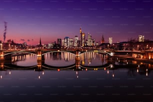 Skyline de Frankfurt na hora azul. prédio iluminado. Em primeiro plano a ponte de jangada.