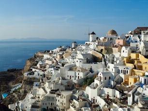 A stunning aerial view of the romantic village of Oia on the island of Santorini at sunset, with its traditional architecture