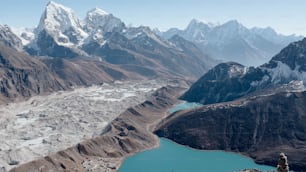 Un tranquillo lago di montagna circondato da cime rocciose innevate nell'Himalaya
