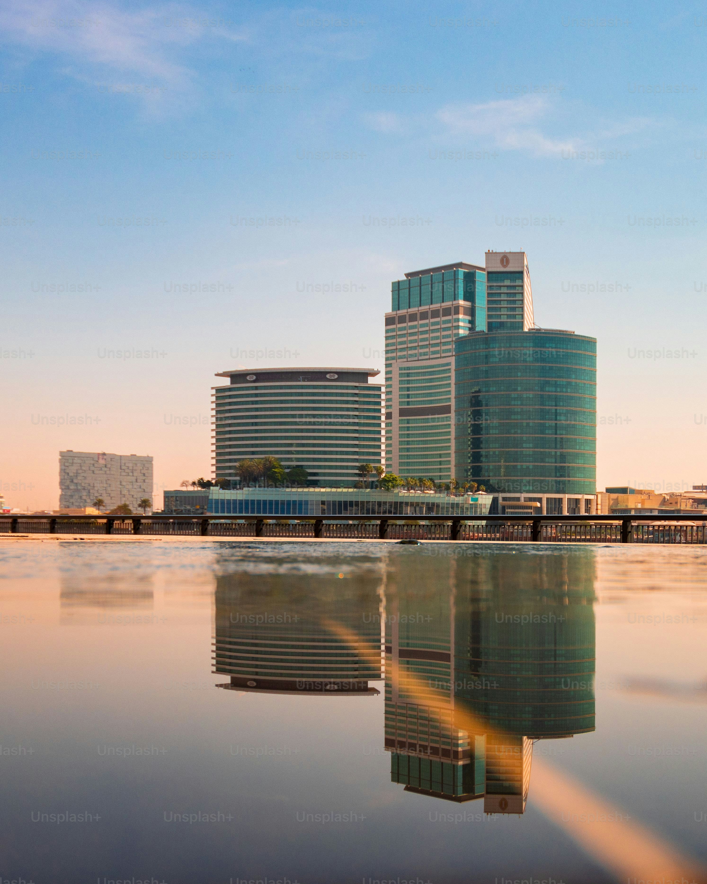 The buildings reflecting in a tranquil pond under a sunset sky in Dubai, UAE.