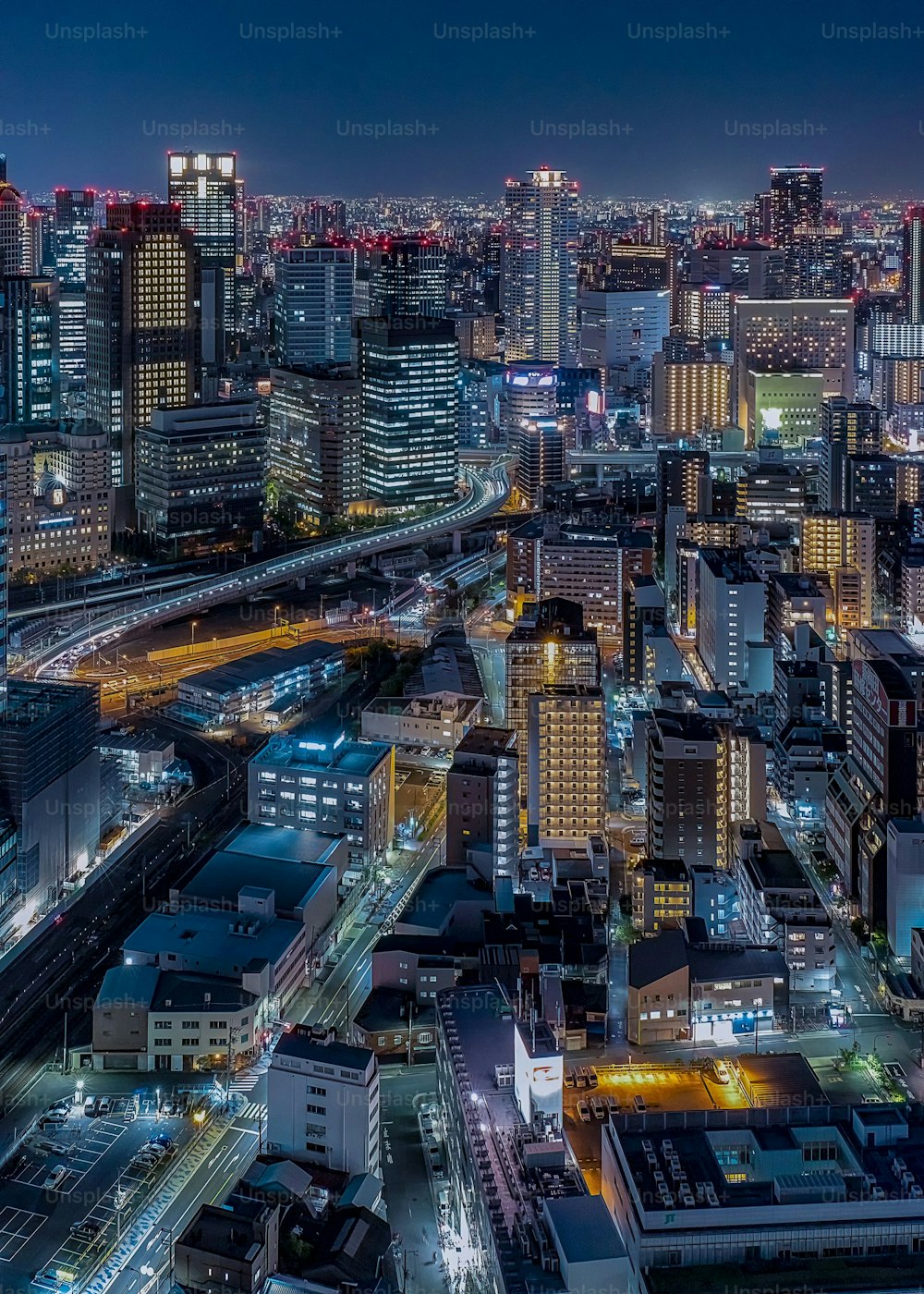 An aerial view of a bustling cityscape with tall skyscrapers at night in Tokyo, Japan