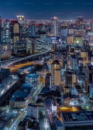 An aerial view of a bustling cityscape with tall skyscrapers at night in Tokyo, Japan
