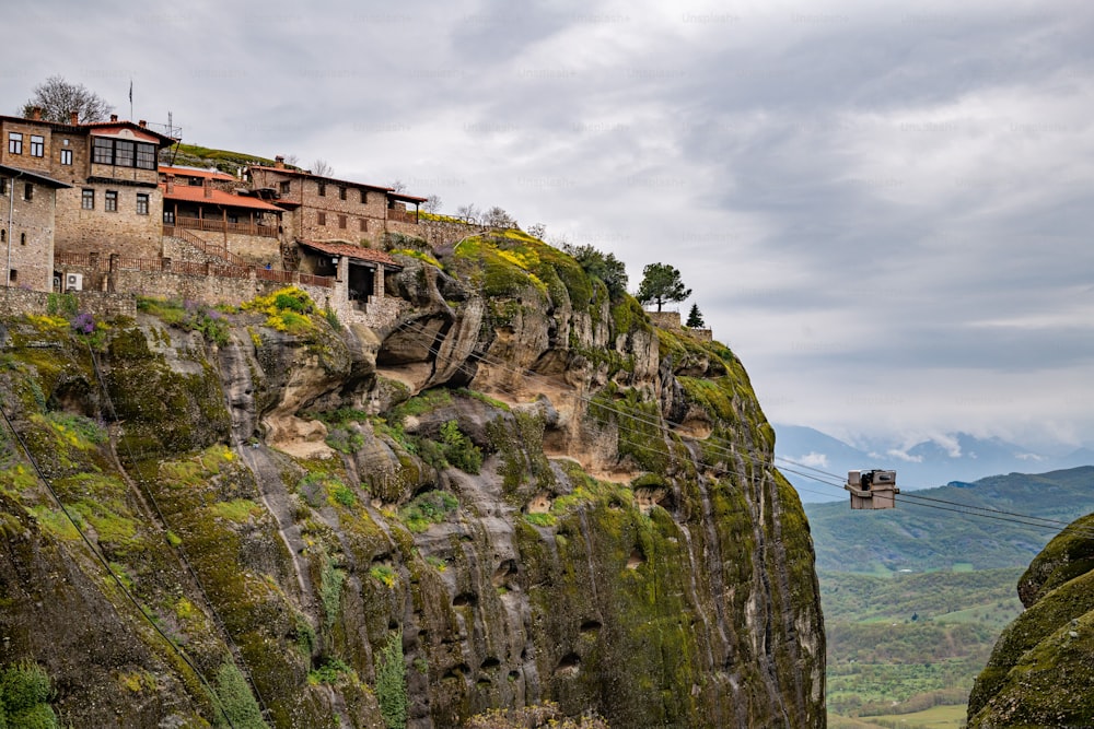 A gondola on a mountaintop with historical buildings. Meteora, Kalabaka, Greece.