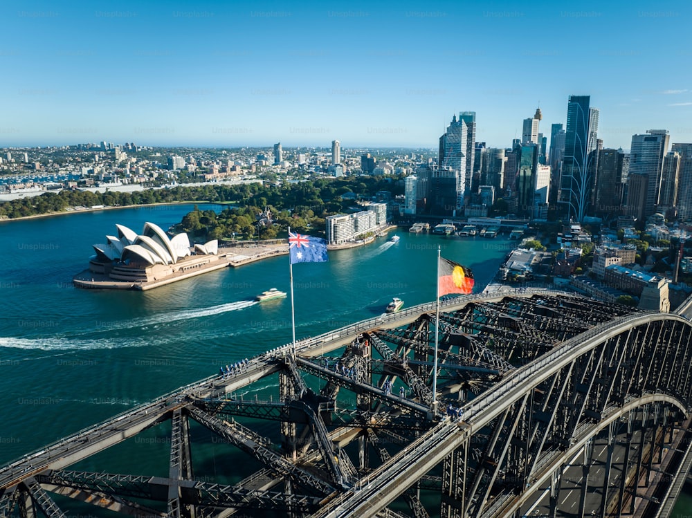 象徴的なシドニーオペラハウスと絵のように美しい港を渡るシドニーハーバーブリッジのあるシドニーの海岸線の空撮