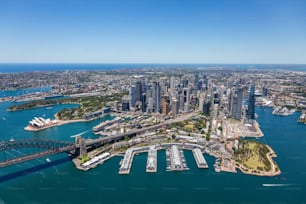 An aerial view of the beautiful Sydney, Australia skyline and its harbor, featuring boats peacefully sailing in the waters