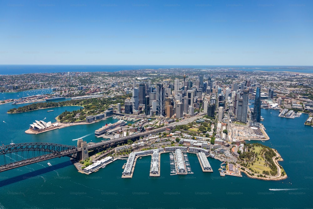 Ein Blick aus der Vogelperspektive auf die wunderschöne Skyline von Sydney, Australien, und seinen Hafen, mit Booten, die friedlich im Wasser segeln