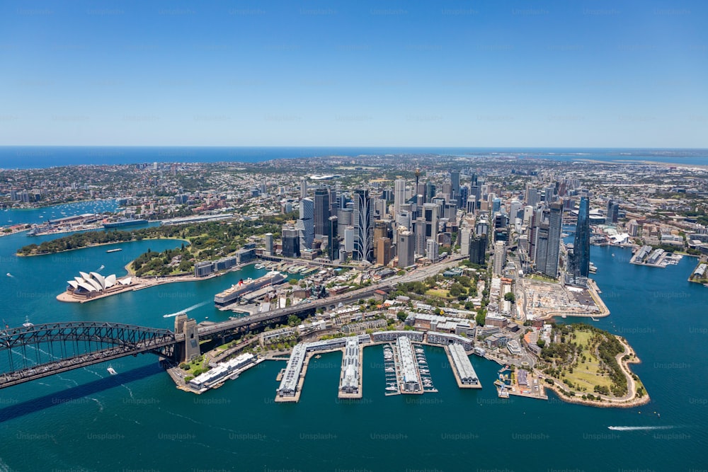 An aerial view of the beautiful Sydney, Australia skyline and its harbor, featuring boats peacefully sailing in the waters