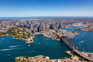 Uma vista aérea do icônico horizonte de Sydney com o porto cintilante e o movimentado centro da cidade ao fundo