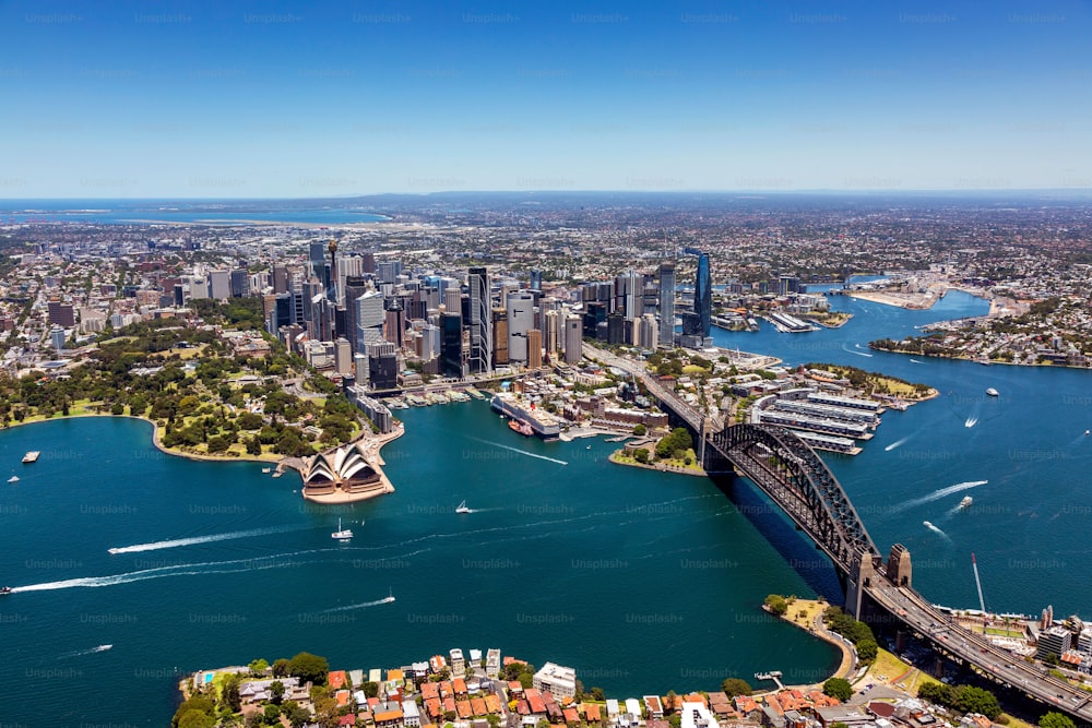 Eine Luftaufnahme der ikonischen Skyline von Sydney mit dem schimmernden Hafen und dem geschäftigen Stadtzentrum im Hintergrund