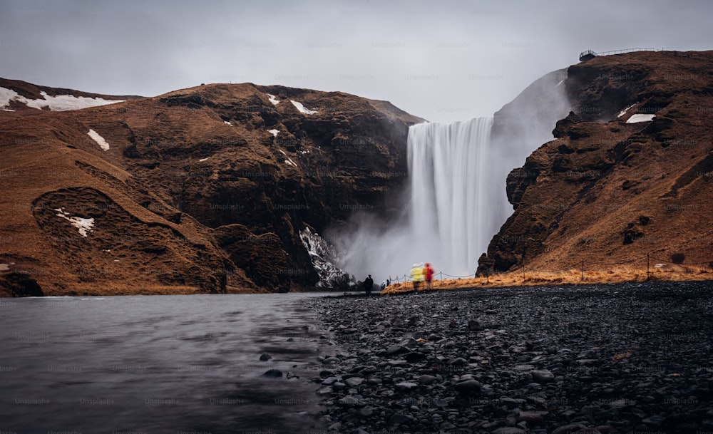 This stunning image from Reykjavik, Iceland features a cascading waterfall amidst a winter wonderland of snow and grass