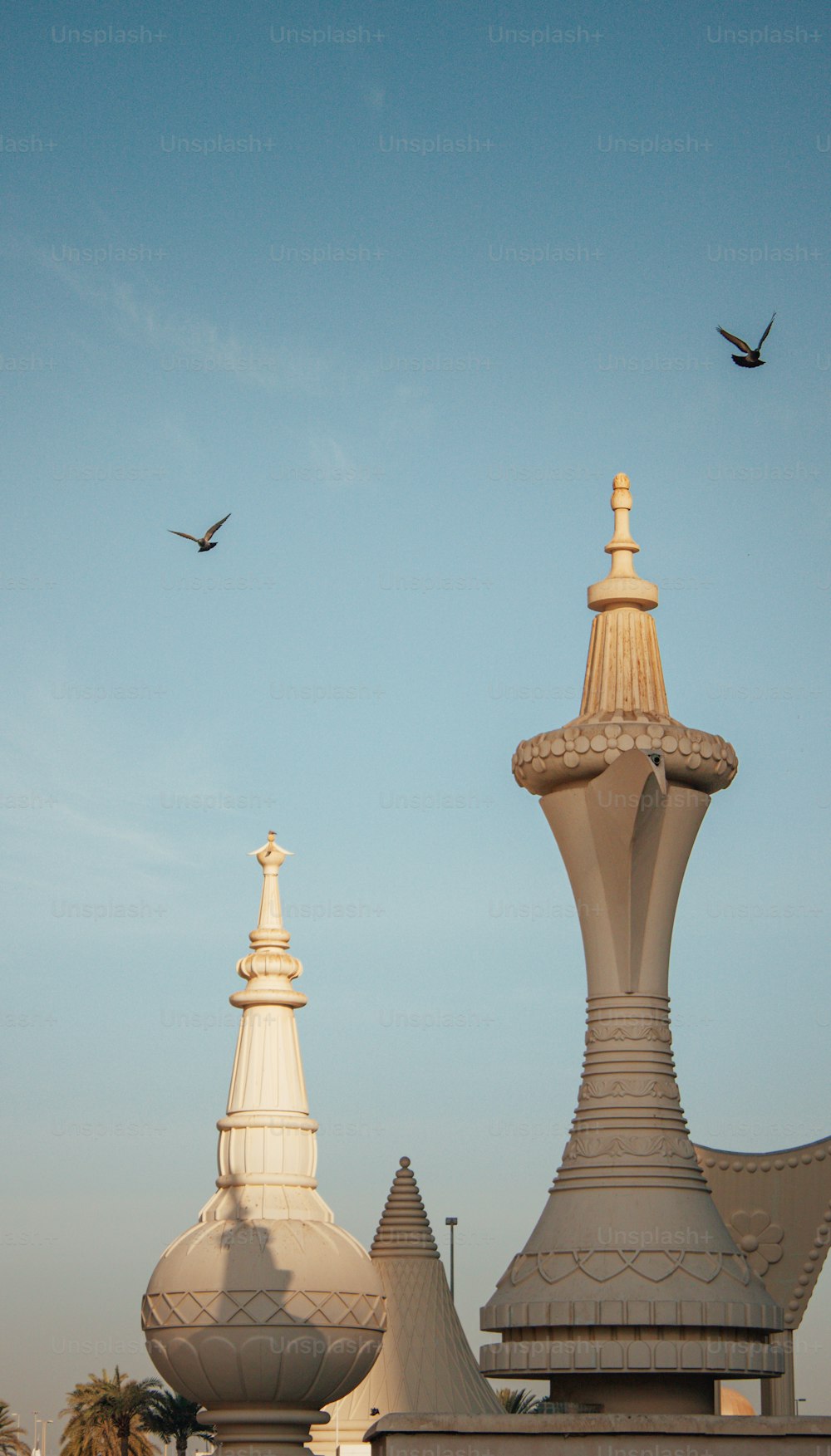 Eine vertikale Aufnahme von The Dallah Coffee Pot in Abu Dhabi unter klarem Himmel mit einem fliegenden Vogel