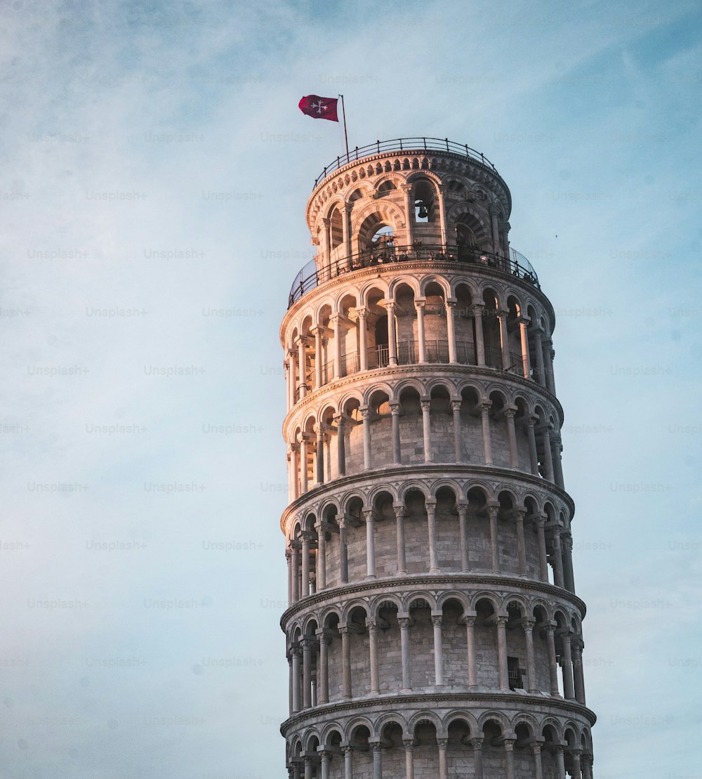 A low angle shot of the Leaning Tower of Pisa under a blue cloudy sky in Italy