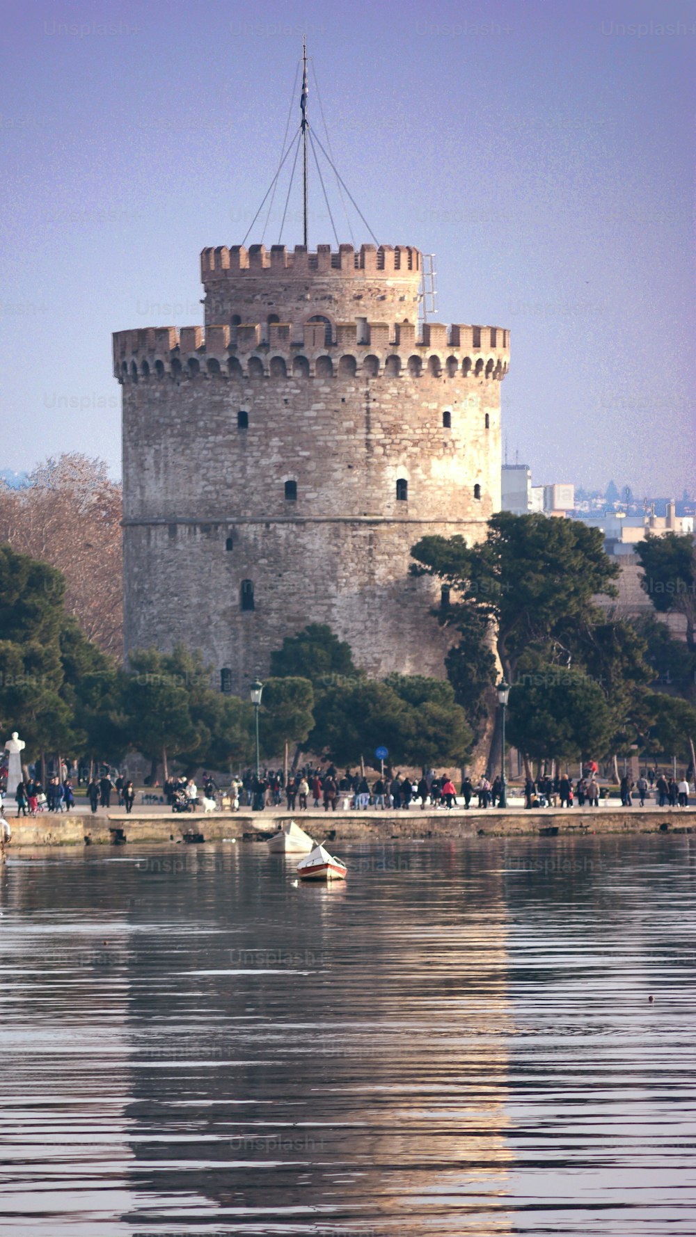 A vertical shot of the White Tower of Thessaloniki at the river