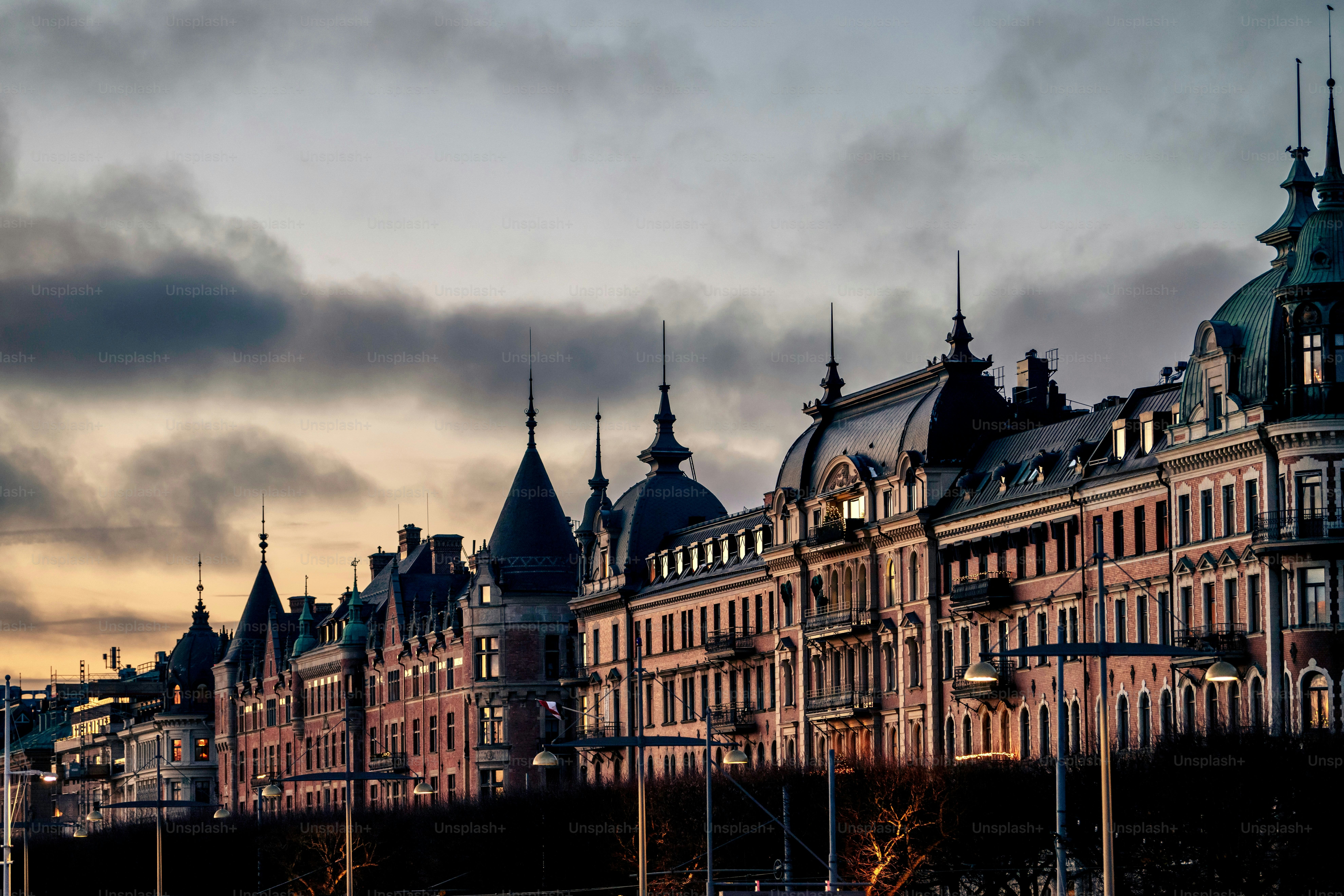 A bustling city street with a traditional Stockholm buildings against the sunset sky