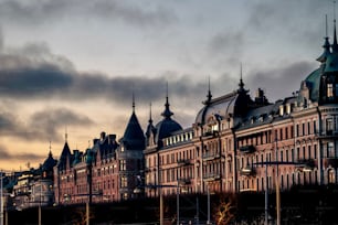 A bustling city street with a traditional Stockholm buildings against the sunset sky