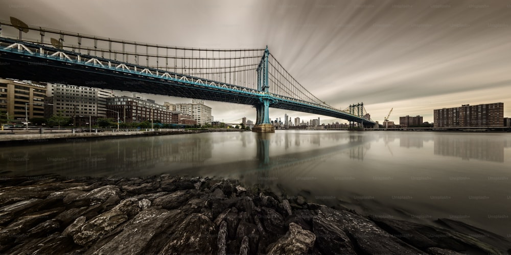 A long-exposure panoramic view of the Manhattan Bridge seen from Brooklyn.