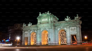 Night view of the Puerta de Alcalá in Madrid, decorated for Christmas.