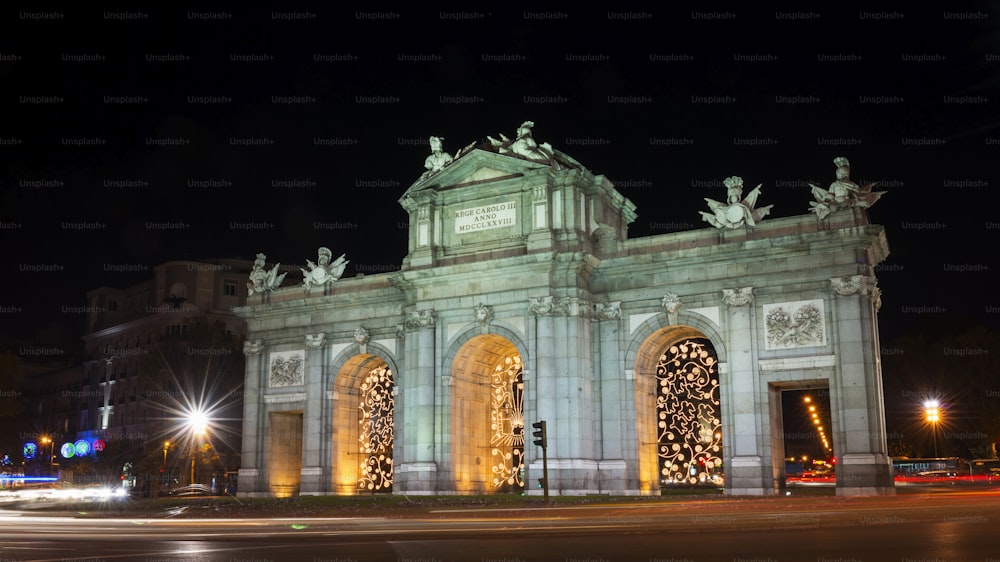 Night view of the Puerta de Alcalá in Madrid, decorated for Christmas.