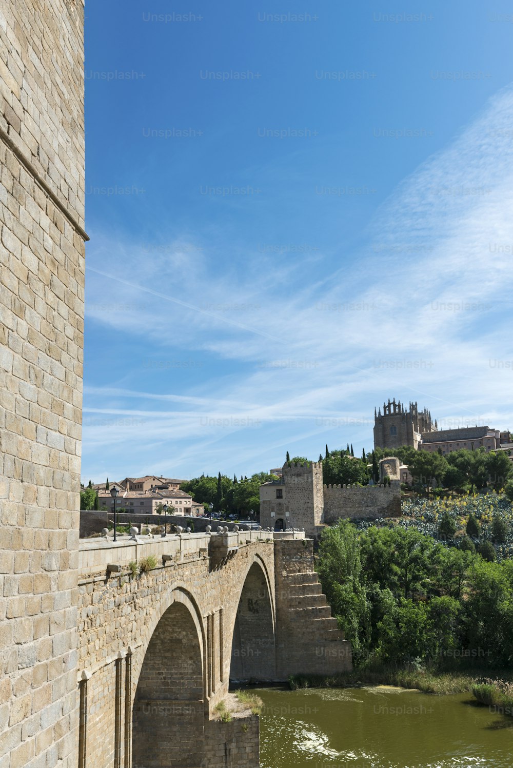 Vista vertical del puente medieval de San Martín y el Monasterio de San Juan en Toledo, España.
