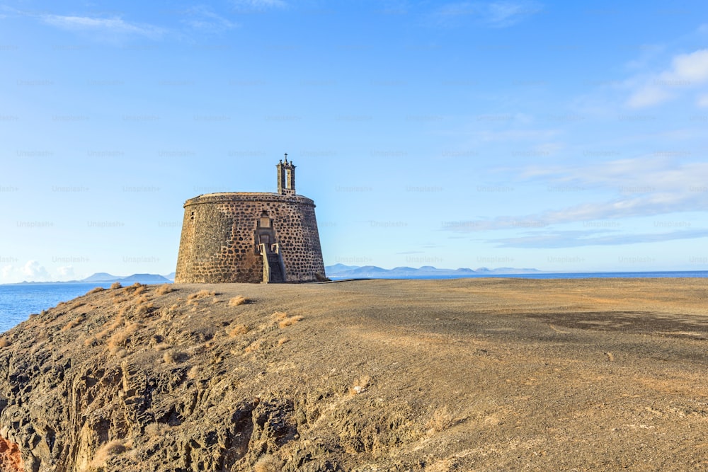 Small castle Castillo de las Coloradas on cliff in Playa Blanca, Lanzarote, Canary Islands, Spain