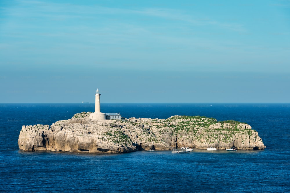 晴れた夏の日に、スペインのサンタンデール湾の入り口にある灯台とモウロ島。