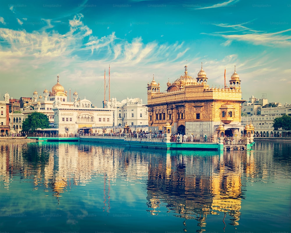 Vintage retro effect filtered hipster style image of famous indian toursit landmark and sacred pilgrimage site - Sikh gurdwara Golden Temple (Harmandir Sahib). Amritsar, Punjab, India