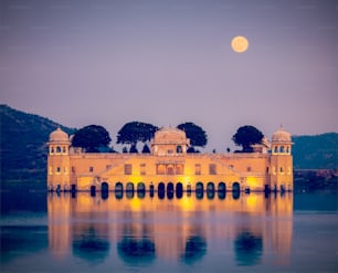 Imagem de viagem vintage de estilo hipster retrô do marco do Rajastão - Jal Mahal (Palácio da Água) no Lago Man Sagar à noite no crepúsculo.  Jaipur, Rajastão, Índia