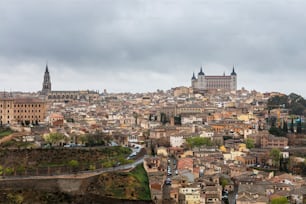 Vista panorámica de Toledo y el río Tajo en un lluvioso día de primavera, con la Catedral y el Alcázar elevándose sobre el horizonte.