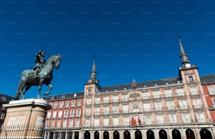 Wide angle view of the Plaza Mayor (Main Square) of Madrid, with the frescoes on the Casa de la Panaderia and the 17th century statue of Felipe III overlooking the square.