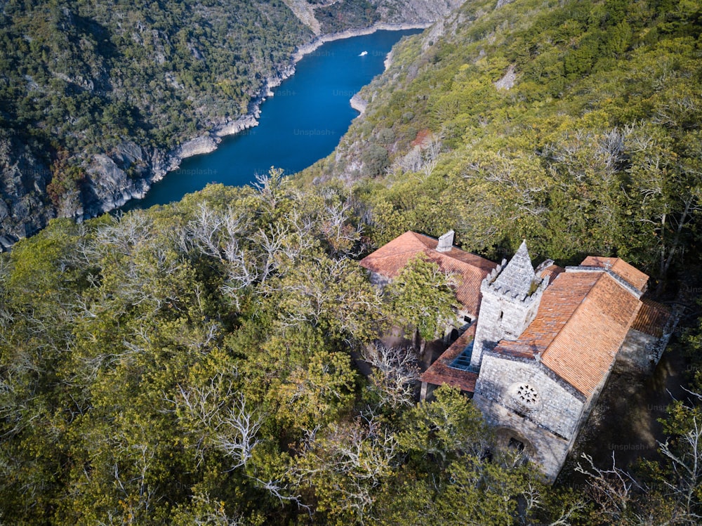 Luftaufnahme von Santa Cristina de Ribas de Sil im Frühherbst, mit der Schlucht des Flusses Sil als natürliche Grenze zwischen den Provinzen Ourense und Lugo in der Ribeira Sacra im Hintergrund.