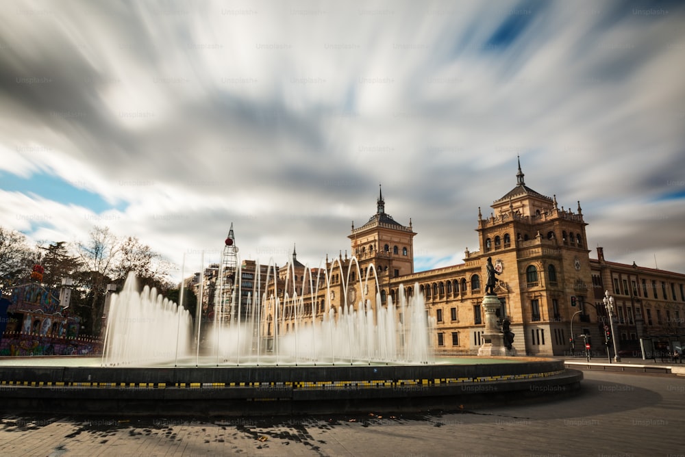 Brunnen auf der Plaza Zorrilla in Valladolid, mit dem Gebäude der Kavallerieakademie im Hintergrund. Lange Belichtung.