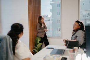 a group of women standing around a white table