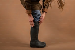 a woman in a brown shirt and black boots