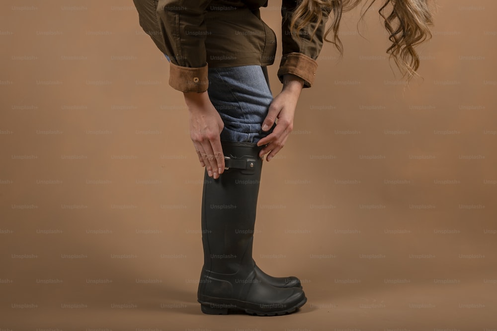 a woman in a brown shirt and black boots